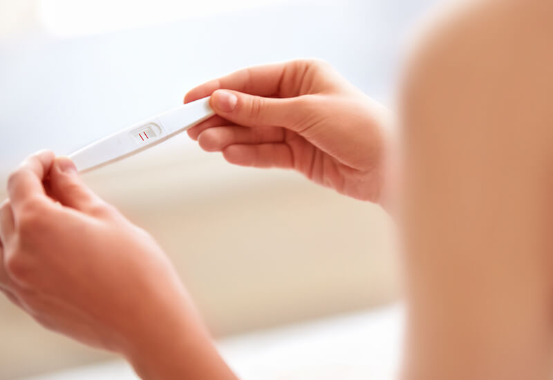 women looking at pregnancy test