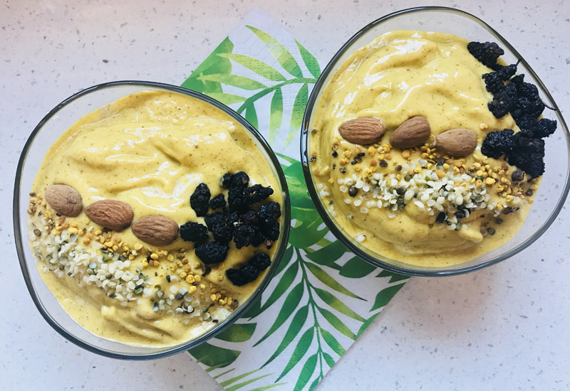 two bowls with mango lassi smoothie in the, on a green serviette